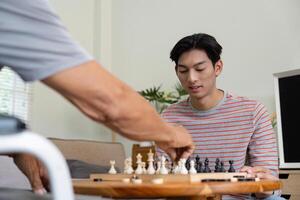 Young man focused on chess game as his father makes a move. photo