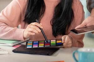 Diverse team member selecting colors for graphic design project. photo