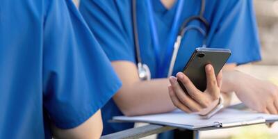 Doctors on a break, using a smartphone and reviewing notes. photo