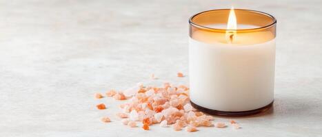 burning candle with warm glow, surrounded by pink salt crystals, creates calming atmosphere. soft light and natural elements evoke relaxation and tranquility photo