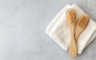 dry brushing set with wooden handles on white towel, perfect for skincare routines and relaxation. Enhance your self care with these eco friendly brushes photo