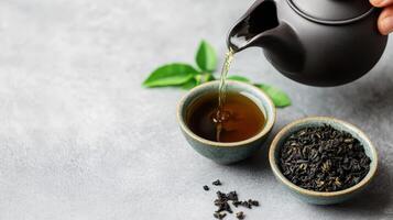 hand pouring herbal tea from teapot into cup, surrounded by tea leaves and loose tea. serene atmosphere evokes relaxation and mindfulness photo