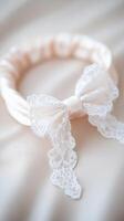 Delicate lace wedding garter with satin band and bow, elegantly placed on soft fabric, perfect for bridal accessories and special occasions photo