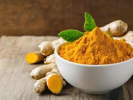 bowl of fresh turmeric and ginger roots with green leaves on wooden surface, showcasing vibrant colors and natural textures. This evokes sense of health and wellness photo