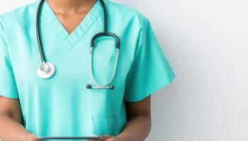 Medical professional in teal scrubs holding tablet with stethoscope photo