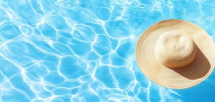 wide brim hat floats on surface of sparkling blue pool, creating serene and relaxing atmosphere. sunlight reflects off water, enhancing tranquil scene photo