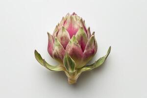 The artichoke features a rich blend of greens and purples, highlighting its layered leaves and intricate design. It rests on a neutral backdrop, emphasizing its beauty photo