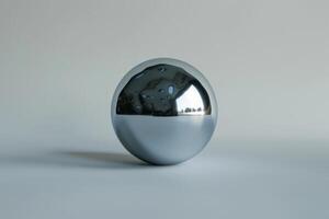 A polished, reflective metallic sphere is placed on a smooth, neutral surface, demonstrating modern design. The sphere mirrors its surroundings, creating an intriguing visual contrast photo