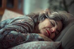 An elderly woman is soundly sleeping on a couch, wrapped in a soft blanket, her peaceful expression reflecting serenity in a warm home setting photo