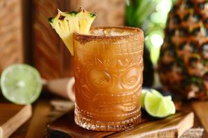 A tiki drink with a pineapple garnish on top photo