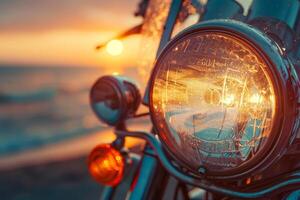 A rustic motorcycle headlight glistens with raindrops as the sun sets over the ocean, casting warm reflections on the chrome surfaces and creating a serene atmosphere photo