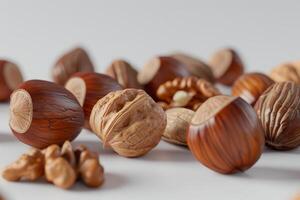 A variety of nuts such as hazelnuts, walnuts, and almonds are scattered on a bright white surface, showcasing their textures and colors in the afternoon light photo