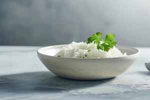 A simple bowl holds fluffy steamed rice, beautifully topped with fresh cilantro leaves. The soft light highlights the rice's texture against a subtle background photo