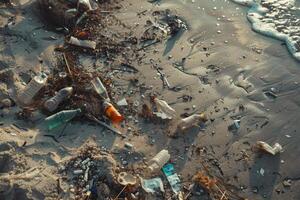 Trash and plastic bottles litter the sandy beach, a stark reminder of environmental issues affecting coastal ecosystems under sunlight photo