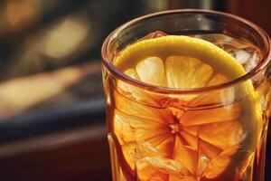 A glass of iced tea filled with ice cubes and adorned with fresh lemon slices sits beside a window, offering a refreshing drink perfect for a sunny day photo