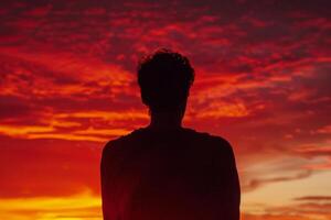 A man is standing in front of a beautiful sunset photo