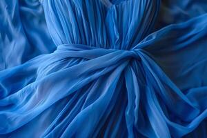 The soft blue fabric cascades elegantly with delicate folds and knots, creating a sophisticated display that captures the beauty of textile design photo