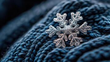 A snowflake is sitting on top of a blue knitted scarf photo
