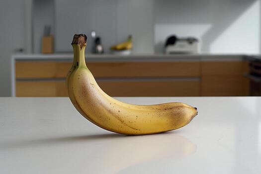 A single ripe banana is positioned on a sleek kitchen countertop, with soft daylight illuminating the space, creating a warm and inviting atmosphere photo