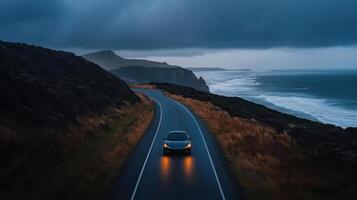 A car driving on a road near the ocean photo