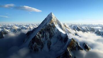A mountain is seen in the clouds with snow on top photo