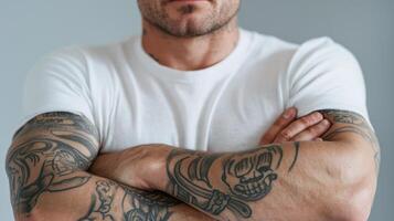 A man with tattoos standing with his arms crossed photo