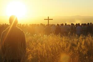 A group of people standing in a field with a cross in the background photo