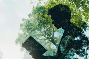 A man reading a book in front of a tree photo