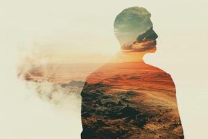 A man standing in front of a sunset with a mountain in the background photo