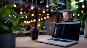 A man sitting at a table with a laptop and a cup of coffee photo