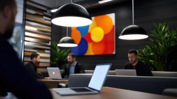 A group of people are sitting at a table with laptops open photo