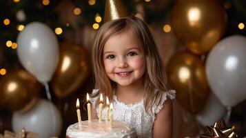 A young girl is sitting in front of a cake with lit candles on it photo
