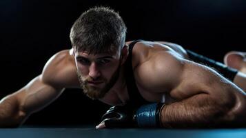 A man with a beard and a black tank top is laying on the ground photo
