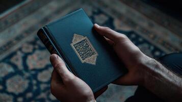 A man is holding a book with a gold embossed cover photo
