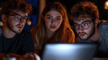 Three people are looking at a laptop screen photo