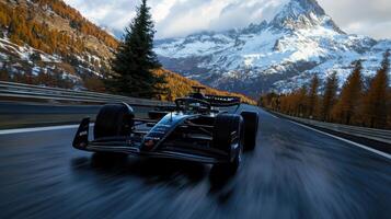 A black race car is speeding down a road in front of a mountain range photo