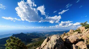 A mountain top with a clear blue sky and clouds photo