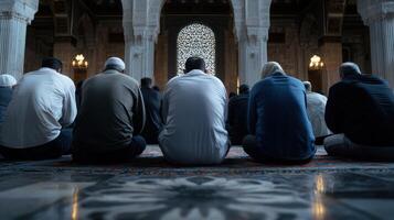 A group of men are sitting on the floor in a mosque photo