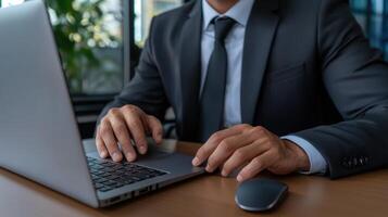 A man in a suit is typing on a laptop photo