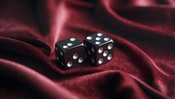 Black dice on a deep red velvet fabric create an elegant and intriguing display for games or decoration photo