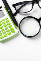 Calculator with a magnifying glass on a white background photo