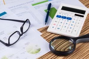 work with a magnifying glass, a calculator and papers photo