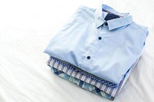 close up of ironed and folded shirts on table at home photo