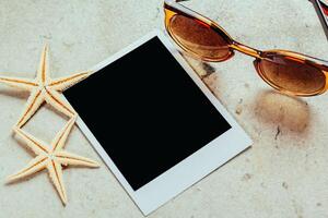 Nautical background with retro sunglasses and empty polaroid photos frames, sea shells