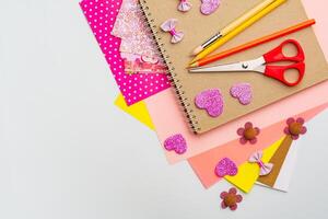 Craft supplies arranged with colorful paper, scissors, and decorations for DIY projects at a workspace photo