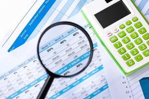 work with a magnifying glass, a calculator and papers photo