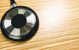 Frying pan on wooden table background. View from above photo