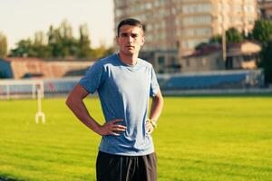 Young athlete rests on a sunny day at the track field with a determined expression before training begins photo