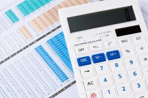 work with a magnifying glass, a calculator and papers photo