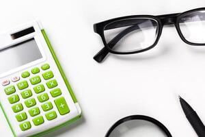Calculator with a magnifying glass on a white background photo